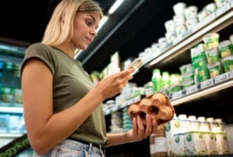 Medium shot of a woman holding an egg carton in a supermarket