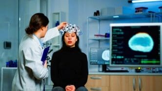 Neurological doctor cheking eeg headset explaining to patient diagnosis of disease and treatment for nervous system
