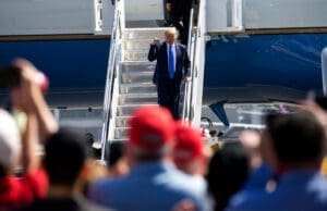 President Donald Trump waves as he steps off Air Force One at John Wayne Airport, Santa Ana, Calif., on Sunday Oct. 18, 2020