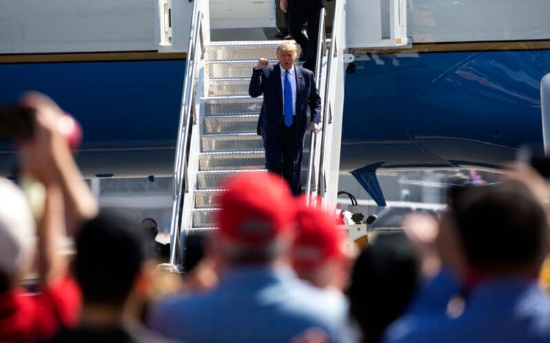 President Donald Trump waves as he steps off Air Force One at John Wayne Airport, Santa Ana, Calif., on Sunday Oct. 18, 2020