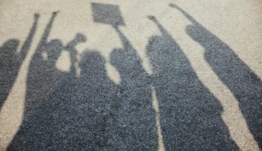 Shadows cast over the asphalt as people of various ages and races gather on the street to protest for equal rights