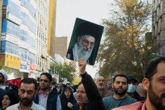Tehran Iran - November 4, 2022, opposition march against America. A man holding a photo of Ayatollah Khamenei. A man who supports the leader of the Islamic Republic of Iran