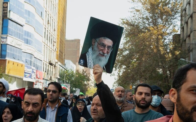 Tehran Iran - November 4, 2022, opposition march against America. A man holding a photo of Ayatollah Khamenei. A man who supports the leader of the Islamic Republic of Iran