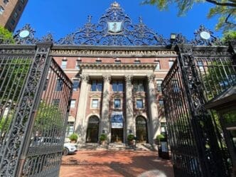 The facade of Barnard Hall seen through the main gates of Barnard College in New York City