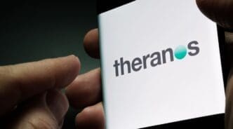 Theranos company logo seen on smartphone screen hold in hand. Stafford, United Kingdom, November 21, 2021