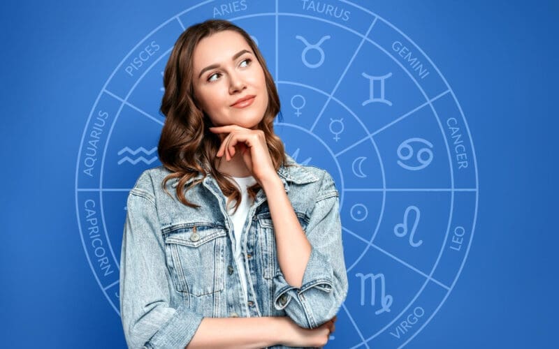 Thoughtful young woman set against the backdrop of a zodiac circle, representing astrology