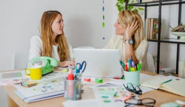 Two women collaborating and exchanging ideas on their projects