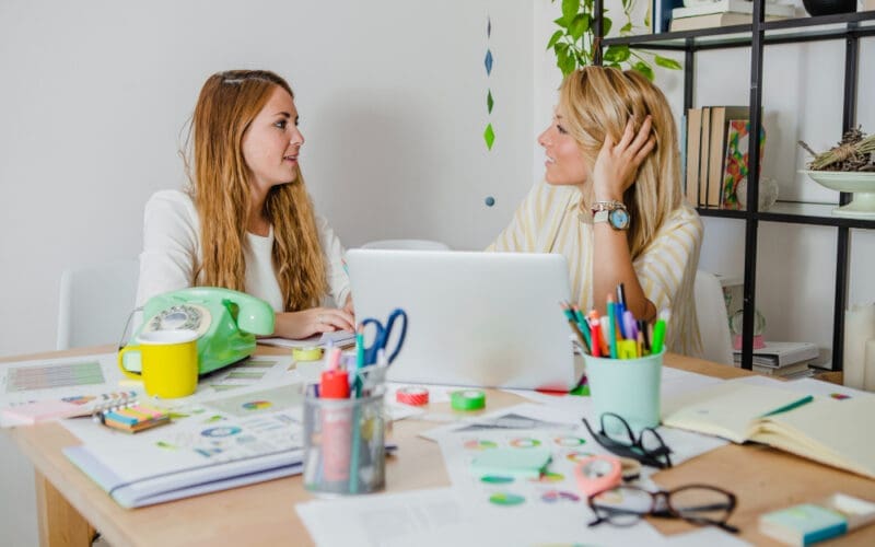 Two women collaborating and exchanging ideas on their projects