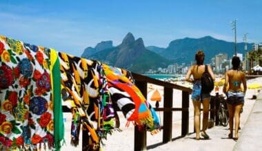 Two women stroll toward Ipanema Beach in Rio de Janeiro on a sunny day