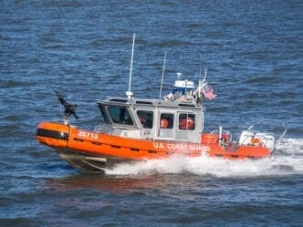 U.S. Coast Guard boat protect Ferry in navigation from Manhattan to Staten Island on Hudson River