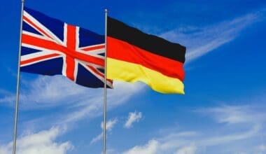 United Kingdom and Germany flags over blue sky background