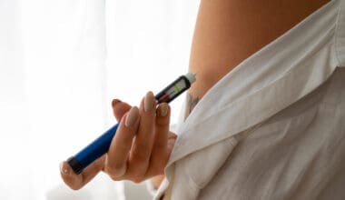 A woman independently administering weight loss medication, such as Ozempic, from a sideways perspective