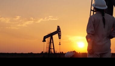 Worker and oil rig against the backdrop of a sunset