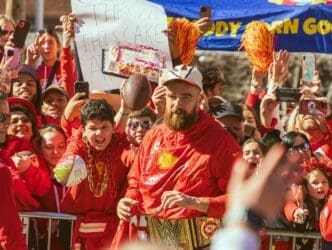 Travis Kelce, a Kansas City Chiefs football player, interacts with fans at a parade