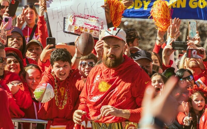 Travis Kelce, who plays the tight end position for the Kansas City Chiefs NFL football team interacts with many fans during the Super Bowl LVIII Parade