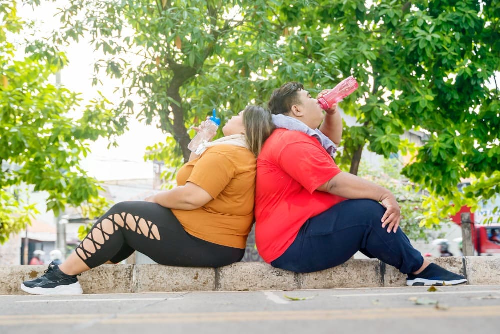 A couple relaxing and hydrating after working out to shed pounds