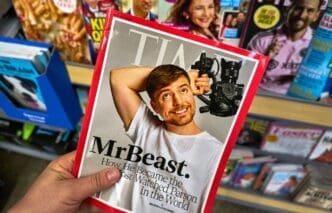 A hand holding Time magazine with James Stephen Donaldson aka MrBeast on cover