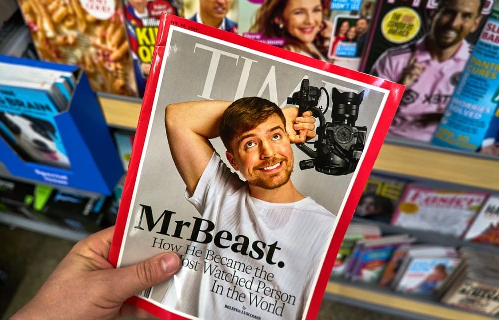 A hand holding Time magazine with James Stephen Donaldson aka MrBeast on cover