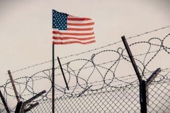 Concept of the Guantanamo Bay Naval Base featuring a wire fence with the US flag, symbolizing immigration and homeland security in the United States