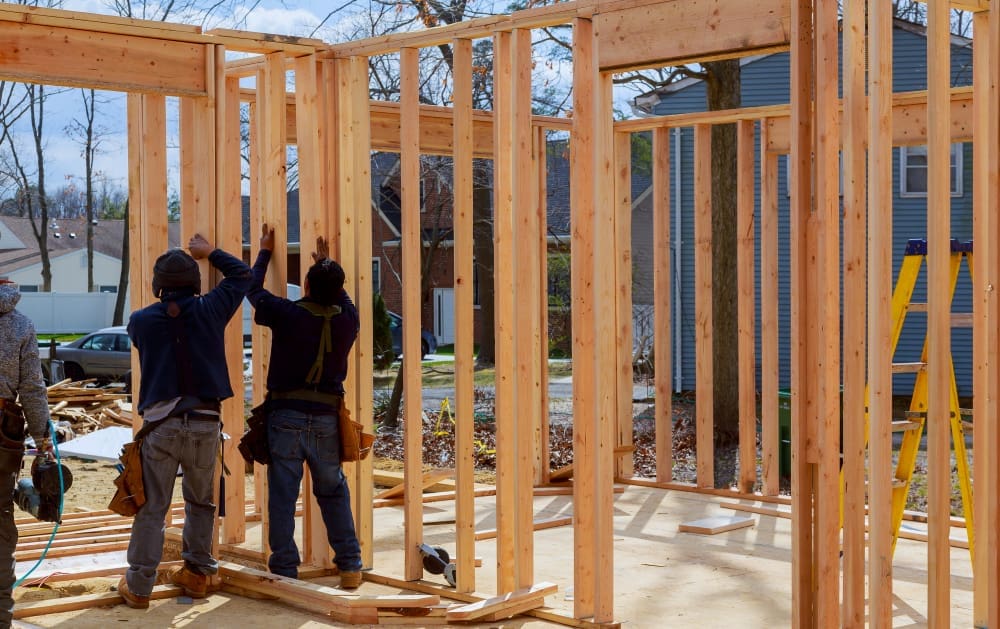 Construction Worker Building Timber Frame In New Home
