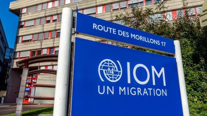 Geneva, Switzerland. Sign at the headquarters of the International Organization for Migration (IOM), the UN intergovernmental agency specializing in migration. By Shutterstock.com - HJBC