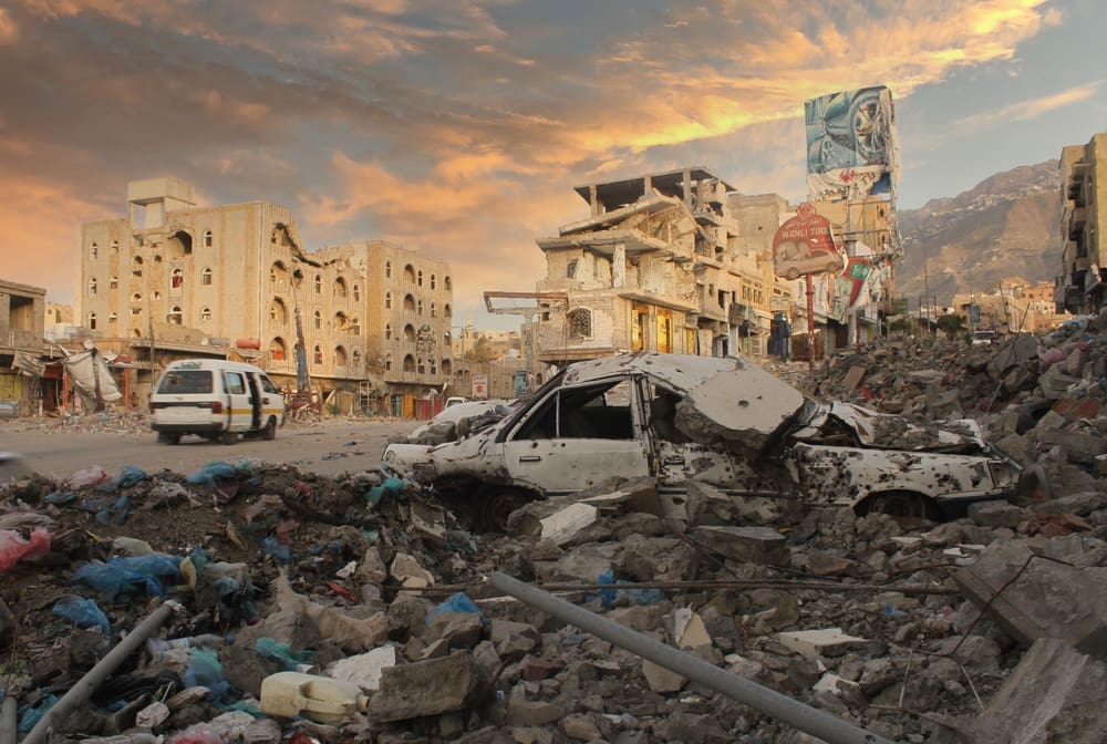 People passed by the buildings that were destroyed during the war between the Popular Resistance and Al-Houthi militia in Taiz City. By Shutterstock.com - Akramalrasny