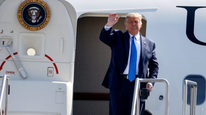President Donald Trump waves as he steps off Air Force One at John Wayne Airport.