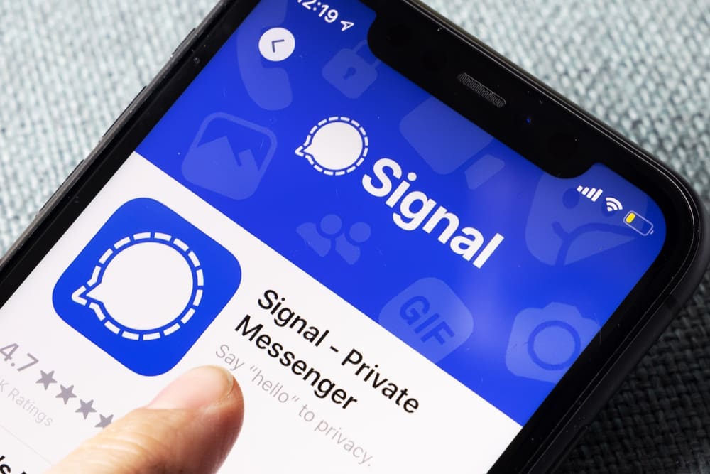 iPhone 11 on blue background with new messenger app Signal logo and icon displayed. Signal is a new application for messaging with high focus on privacy. By Shutterstock.com - Boumen Japet
