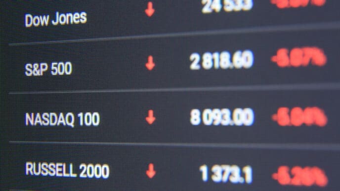 Macro shot of computer monitor with world stock market chart in trading application. Dow Jones, S&P 500, Nasdaq 100, Russell 2000 indexes falling down