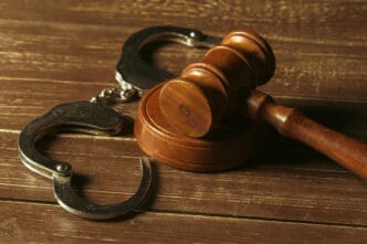 Closeup view of brown wooden mallet of judge and handcuffs
