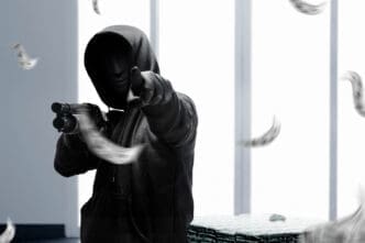 A masked criminal brandished a shotgun, aiming it threateningly at the scene as he demanded compliance during the robbery