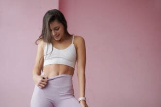 A slim, beautiful woman admires her abs