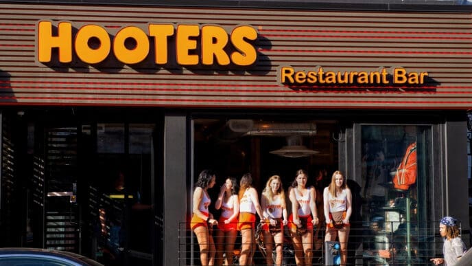 Montreal, Canada - May 27, 2017: Hooters girls at the window of the restaurant on the trendy Crescent St that opened in March of 2017. It is part of a US based casual dining chain