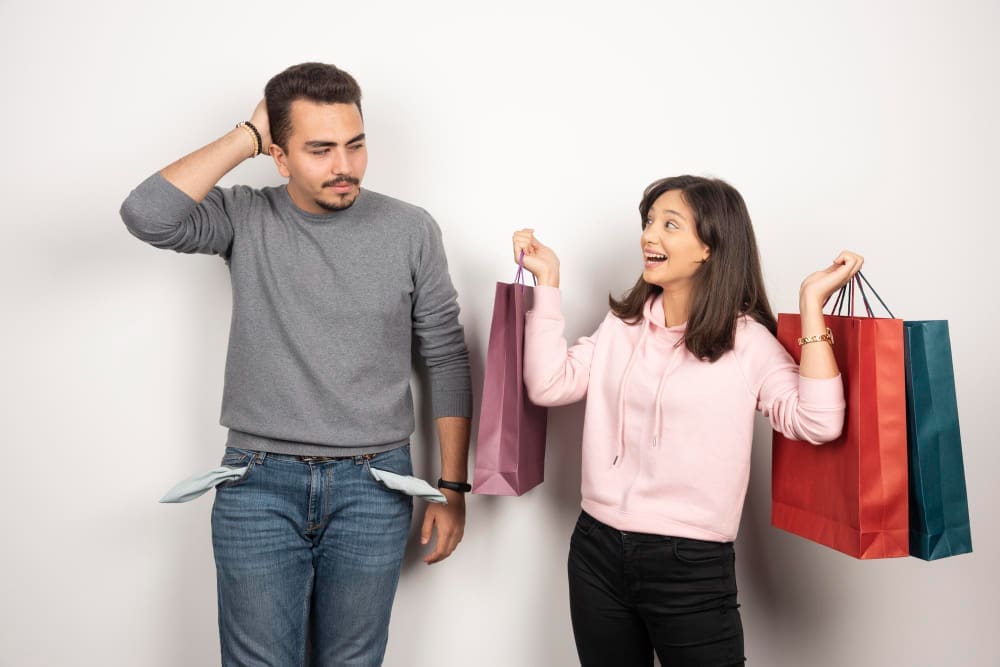 Joyful Woman Shopping While Her Exhausted Husband Reflects the Strain of Excessive Consumerism