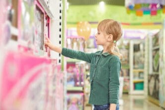 Kid choosing toys for purchase in big store