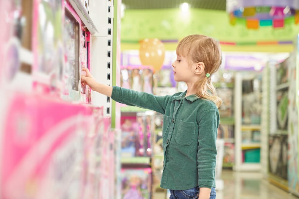 Kid choosing toys for purchase in big store