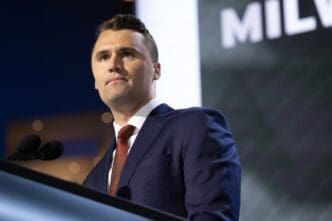 Turning Point USA CEO Charlie Kirk looks out at the audience while speaking at a podium