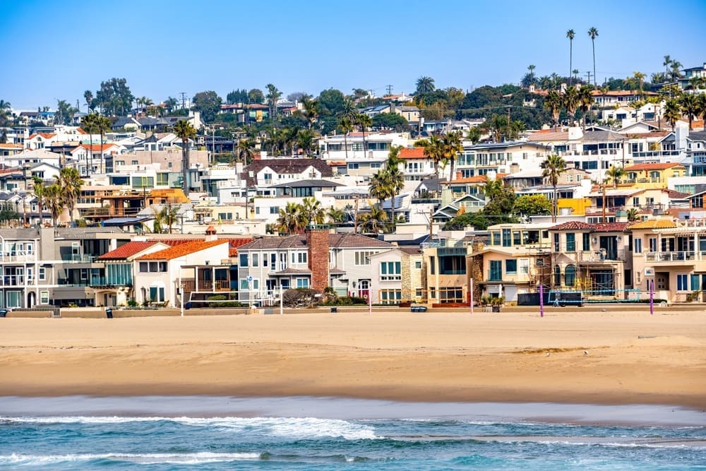 Sunny beachfront homes and walkways in the South Bay, bathed in daylight under blue skies and offering clear views. By Shutterstock.com - WebandWalls
