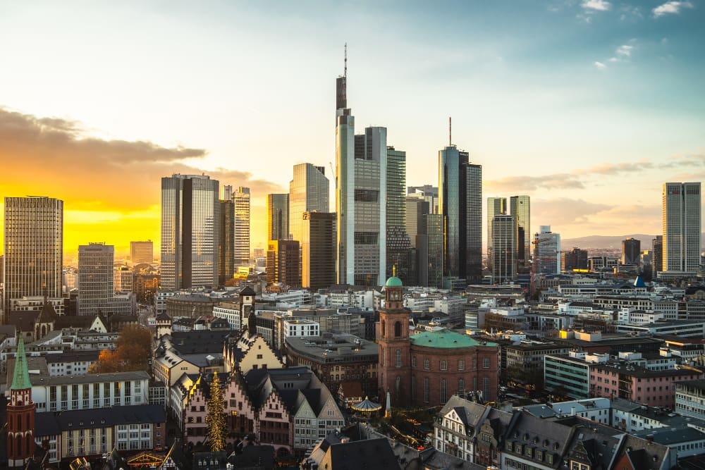 The cityscape of Frankfurt's financial district is adorned with modern buildings at sunset