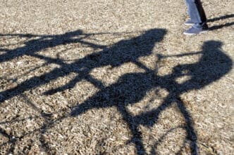 Adult man (Child Sex Offender) watching children playing in the playground trying to steal child. Kidnapping and child abuse concept.