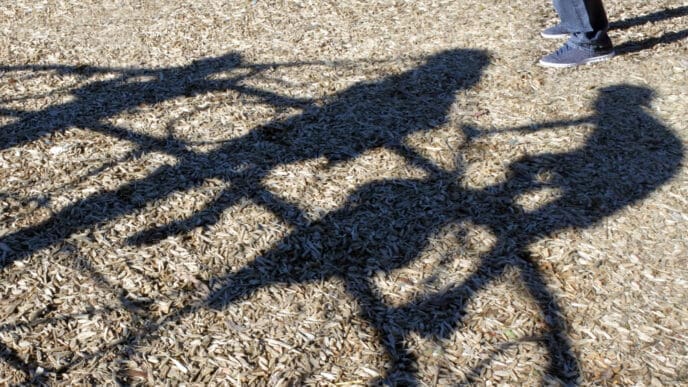Adult man (Child Sex Offender) watching children playing in the playground trying to steal child. Kidnapping and child abuse concept.