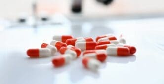 Red tablets scattered on the table of the pharmaceutical laboratory pill for the prescription and treatment of various diseases chemistry
