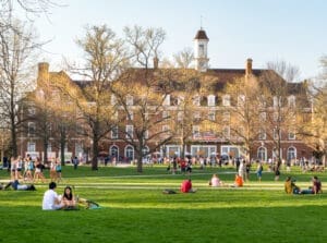 URBANA, ILLINOIS - APRIL 17, 2016: Students walk and sit outside on Quad lawn of University of Illinois college campus in Urbana Champaign