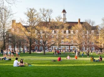 URBANA, ILLINOIS - APRIL 17, 2016: Students walk and sit outside on Quad lawn of University of Illinois college campus in Urbana Champaign