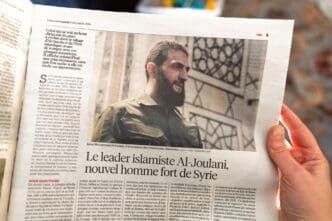 Paris, France - Dec 9, 2024: Newspaper article discussing Al-Joulani's evolution from Islamist leader to Syria's emerging political figure with his controversial stance and regional impact.