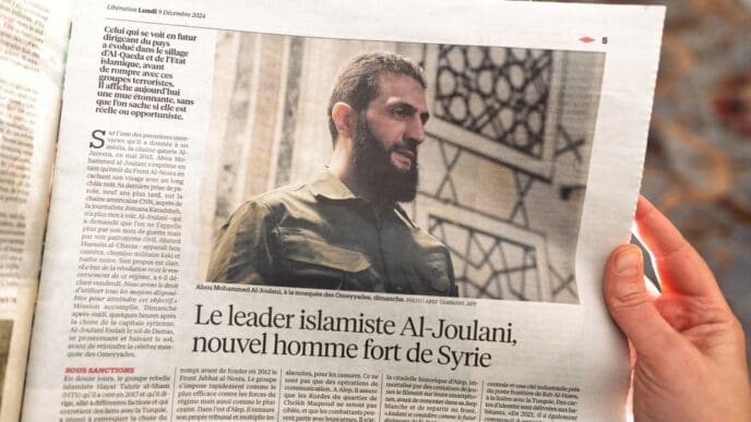 Paris, France - Dec 9, 2024: Newspaper article discussing Al-Joulani's evolution from Islamist leader to Syria's emerging political figure with his controversial stance and regional impact.