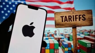 New York, USA- 19 Apr 2025: Selective focus on smartphone screen holding in hand displaying Apple Inc i phone logo with the background of US high Tariffs on Export, Import and Tariff War in the world.
