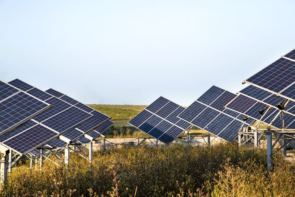 A solar power station's photovoltaic panels set against a natural background