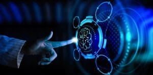 A person's finger touches a glowing blue, futuristic interface, activating a central icon of a brain with the letters "AI" inside, symbolizing artificial intelligence.