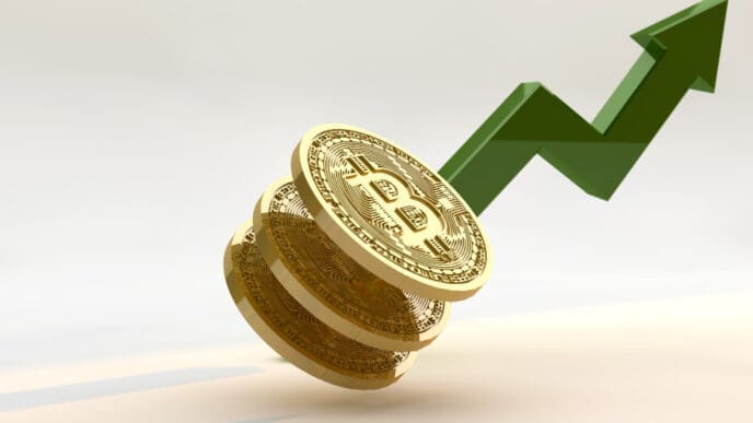 A 3D rendering of three golden Bitcoin coins stacked on a light surface, with a large green arrow rising sharply upwards behind them, symbolizing cryptocurrency growth.